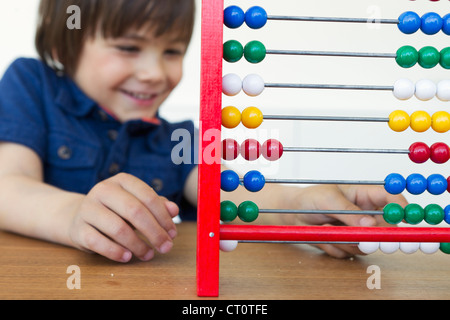 Lächelnde junge spielt mit abacus Stockfoto