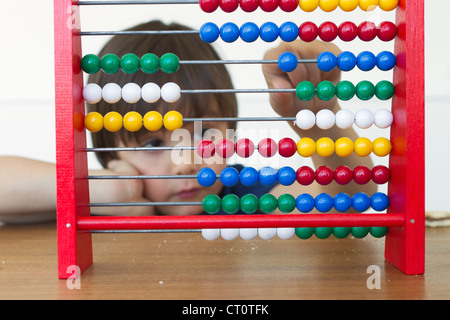 Jungen spielen mit abacus Stockfoto