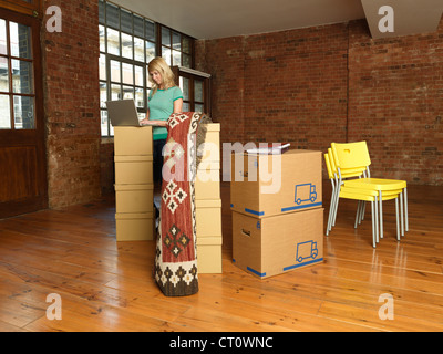 Frau mit Karton Boxen im neuen Zuhause Stockfoto