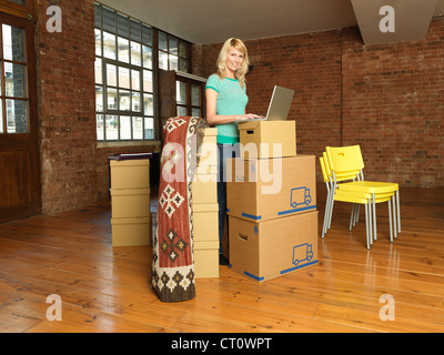 Frau mit Karton Boxen im neuen Zuhause Stockfoto