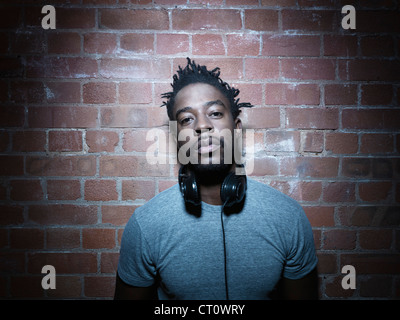 Mann trägt Kopfhörer um Hals Stockfoto