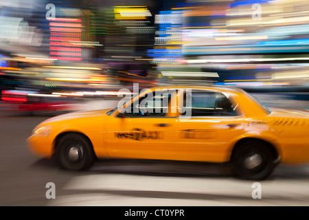 Bewegung verwischt Bild von einem gelben New York Taxi fahren in Manhattan bei Nacht. Stockfoto
