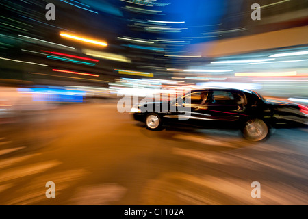 Bewegung verwischt Bild einer schwarzen Limousine fahren durch Manhattan in New York bei Nacht. Stockfoto
