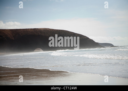 Wellen, die am Sandstrand Stockfoto