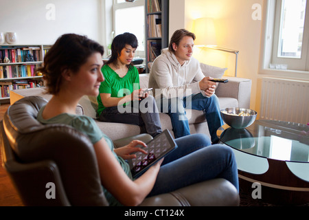 Freunde, die gemeinsam im Wohnzimmer entspannen Stockfoto