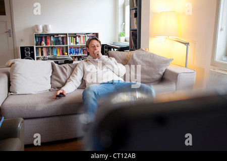 Mann vor Fernseher Gähnen Stockfoto