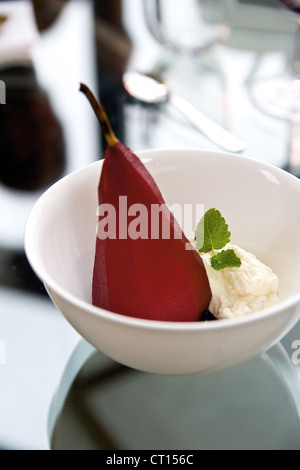 Schüssel mit gebackener Birne und Sahne Stockfoto