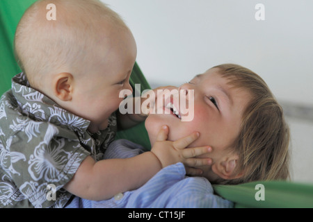 Baby und Bruder spielt auf couch Stockfoto