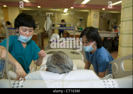 Medizinisches Personal kümmern sich um ein Patient auf der Intensivstation, Samsung Medical Center; Südkorea. Stockfoto