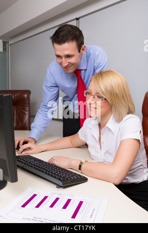 Zwei glückliche Geschäftspartner auf Computer in ihrem Büro arbeiten. Stockfoto