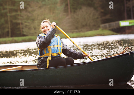 Frau Rudern Kanu auf noch See Stockfoto