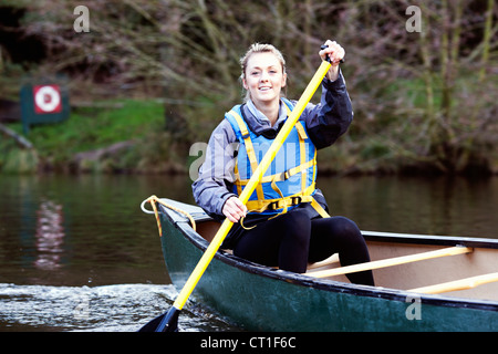 Frau Rudern Kanu auf noch See Stockfoto