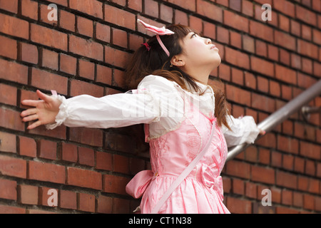 betonte japanische Lolita Cosplay Ziegelwand gelehnt, auf Treppen Stockfoto