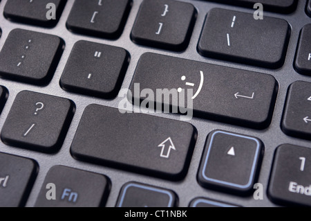 ein glückliches Smiley-Zeichen auf enter-Taste der Tastatur. Stockfoto