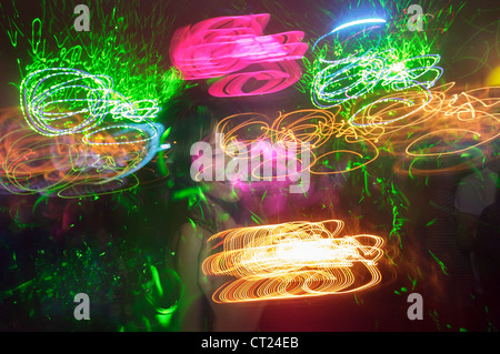 Langzeitbelichtung von Frau tanzt im Nachtclub mit Beleuchtung Stockfoto