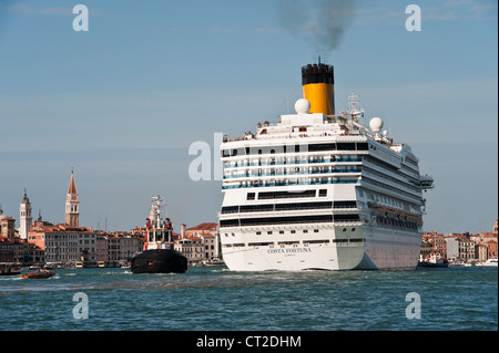 Das riesige Kreuzfahrtschiff Costa Fortuna (im Besitz der Reederei Carnival Corporation) wird an der Giudecca in Venedig, Italien, vorbeigeschleppt Stockfoto