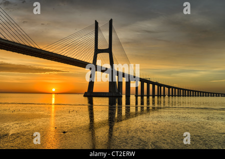 Vasco da Gama-Brücke in Lissabon, Portugal bei Sonnenaufgang mit Reflexion in den Tejo Stockfoto