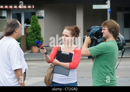 TV-Team männlichen Kameramann weibliche Reporter Interview auf Straße interviewen Mann in der Öffentlichkeit - Heilbronn, Deutschland Stockfoto