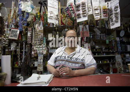 Speichern Sie Inhaber hinter der Theke in seinem Botanica Shop, East Harlem, New York City. Stockfoto