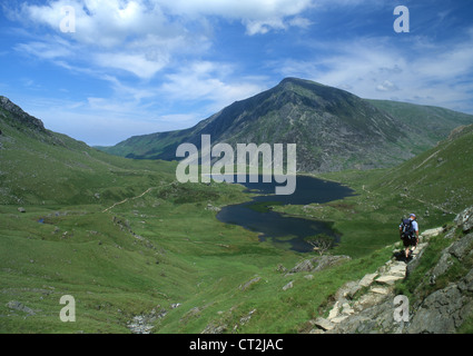 Einsame männliche Walker auf Weg in Teufels Küche mit Llyn Idwal und Stift Yr Ole Wen in Ferne Snowdonia Gwynedd North Wales UK Stockfoto