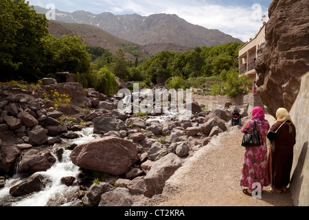 Einheimische Frauen durch einen Fluss, Dorf Imlil, hohe Atlasgebirge, Marokko, Afrika Stockfoto