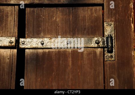 Antike Holztür mit Metallscharnieren. Stockfoto