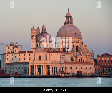 Die Barockkirche Santa Maria della Salute, Venedig, Italien (1681), bei Sonnenaufgang mit der Kunstgalerie Punta della Dogana im Vordergrund Stockfoto