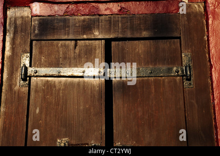 Antike Holztür mit Metallscharnieren. Stockfoto