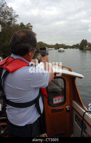 Broads Behörde Navigation Officer mit Radar Geschwindigkeit Gewehr auf dem Fluss Bure außerhalb des Nationalparks Wroxham, Norfolk Broads Stockfoto