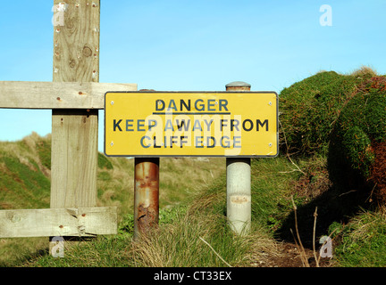 Ein Gefahrenzeichen auf dem Küstenpfad in der Nähe von Newquay in Cornwall, Großbritannien Stockfoto