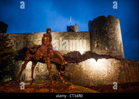 Bronzestatue der zwei Könige Harlech Castle beleuchtet Nacht Harlech Vereinigtes Königreich / HARLECH, Wales — Ivor Roberts-Jones Bronzeskulptur die zwei Könige stehen vor den massiven Steinmauern von Harlech Castle beleuchtet. Die Figuren aus dem Mabinogion zeigen Bendigeidfran, der das Kind Gwern trägt und das Denkmal in der walisischen Mythologie an einem Ort verwurzelt, der zur Durchsetzung der englischen Dominanz gebaut wurde. Die von Eduard I. zwischen 1283 und etwa 1289 errichtete konzentrische Festung wurde 1404 von Owain Glyndŵr eingenommen und diente vor Falli als Hof, Familiensitz und Militärquartier Stockfoto