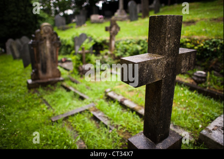 HARLECH, Wales – Ein Schotterpfad schlängelt sich durch verwitterte Grabsteine auf dem Friedhof der St. Tanwg's Church in Harlech, an der Nordwestküste von Wales. Die historische Kirche, eingebettet in die Region Snowdonia, steht am Ende des Weges, ihre Steinmauern zeugen von jahrhundertelanger walisischer religiöser Tradition und dem Leben an den Küsten. Stockfoto