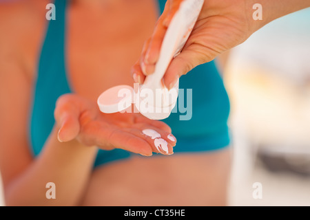 Closeup auf weibliche Hand drückte Sonnencreme Bildschirm Stockfoto