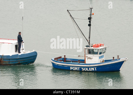 Schlepper ziehen ein Schiff im Hafen von Portsmouth Stockfoto
