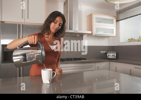 Frau Tasse Tee in der Küche zu machen Stockfoto