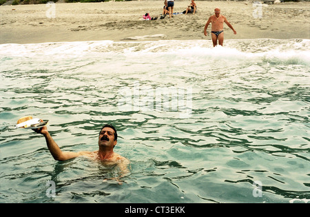 Alanya, schwimmt Man im Meer mit einem vollen Teller Stockfoto