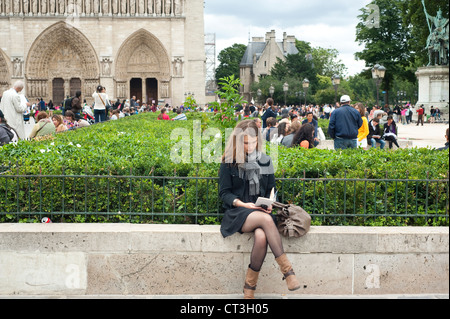 Paris, Frankreich - eine junge Frau, die ein Buch rund um die Kathedrale Notre Dame. Stockfoto