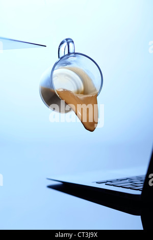 Tasse Kaffee verschüttet auf laptop Stockfoto