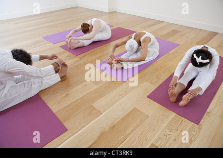 Menschen Sie Yoga zu praktizieren gemeinsam in der Klasse Stockfoto