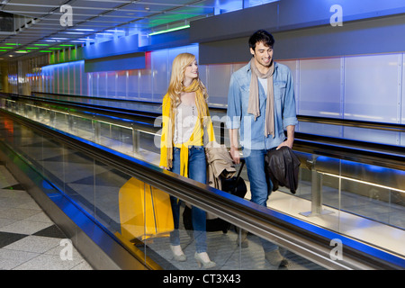 Paar am Laufband am Flughafen Stockfoto