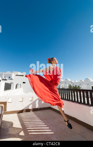 Attraktive Flamencotänzerin, die traditionellen rotes Kleid mit Blume im Haar tragen Stockfoto