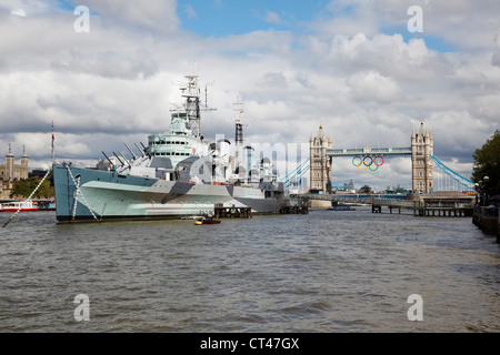 Battleship WW2, vertäut HMS Belfast auf der Themse mit Tower Bridge mit Olympischen Ringen geschmückt. London 2012 Stockfoto