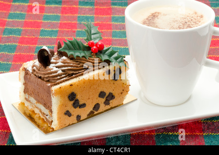 Buchette de Noel mit ein Milchkaffee. Die klassischen Buche de Noel ist die Französisch Weihnachten Kuchen in der Form eines Yule log. Stockfoto