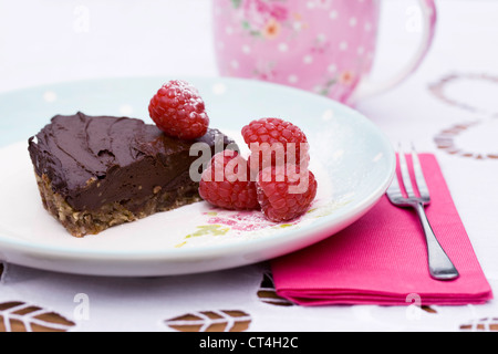 Ein Stück rohe Schokolade Tarte mit Himbeeren. Stockfoto