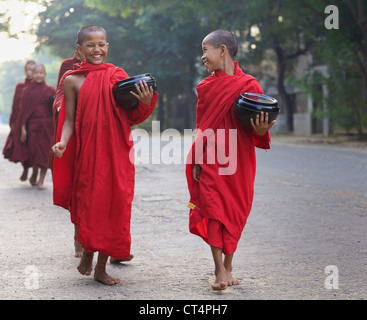 Zwei nicht identifizierte junge Novizen gehen morgen Almosen in Old Bagan, Myanmar Stockfoto