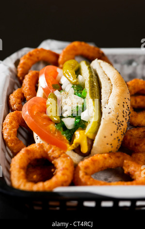 Ein Chicago Hot Dog und Zwiebel Ringe in einem Korb. Stockfoto