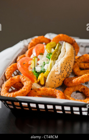 Ein Chicago Hot Dog und Zwiebel Ringe in einem Korb. Stockfoto