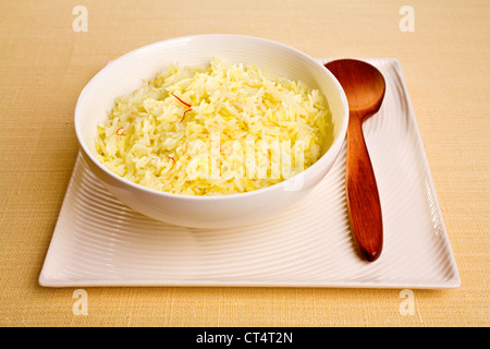 Basmatireis gekocht mit Safran, Ghee und Lager, in eine Runde Schale auf einer quadratischen Platte gesetzt. Stockfoto