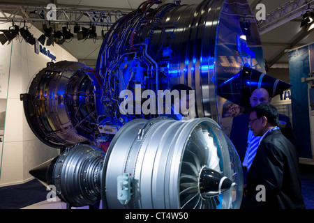 Potenzielle Käufer diskutieren Trent-Triebwerke mit Rolls-Royce-Mitarbeiter auf der Farnborough Air Show. In einem der wichtigsten Hallen wo Hersteller und Aussteller ihre Produkte für die Verteidigungs- und Luftfahrtindustrie präsentieren, beschreibt ein RR-Mitarbeiter die technischen Vorzüge der Trent Familie Turbofan, deren Aufträge helfen Arbeitsplätze bei den Fabriken des Unternehmens zu erhalten. Stockfoto