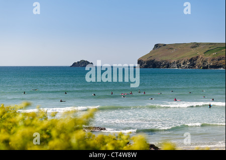 Surfer im Meer warten auf eine Welle an Polzeath Bucht an einem sonnigen Sommertag in Cornwall zu fangen Stockfoto